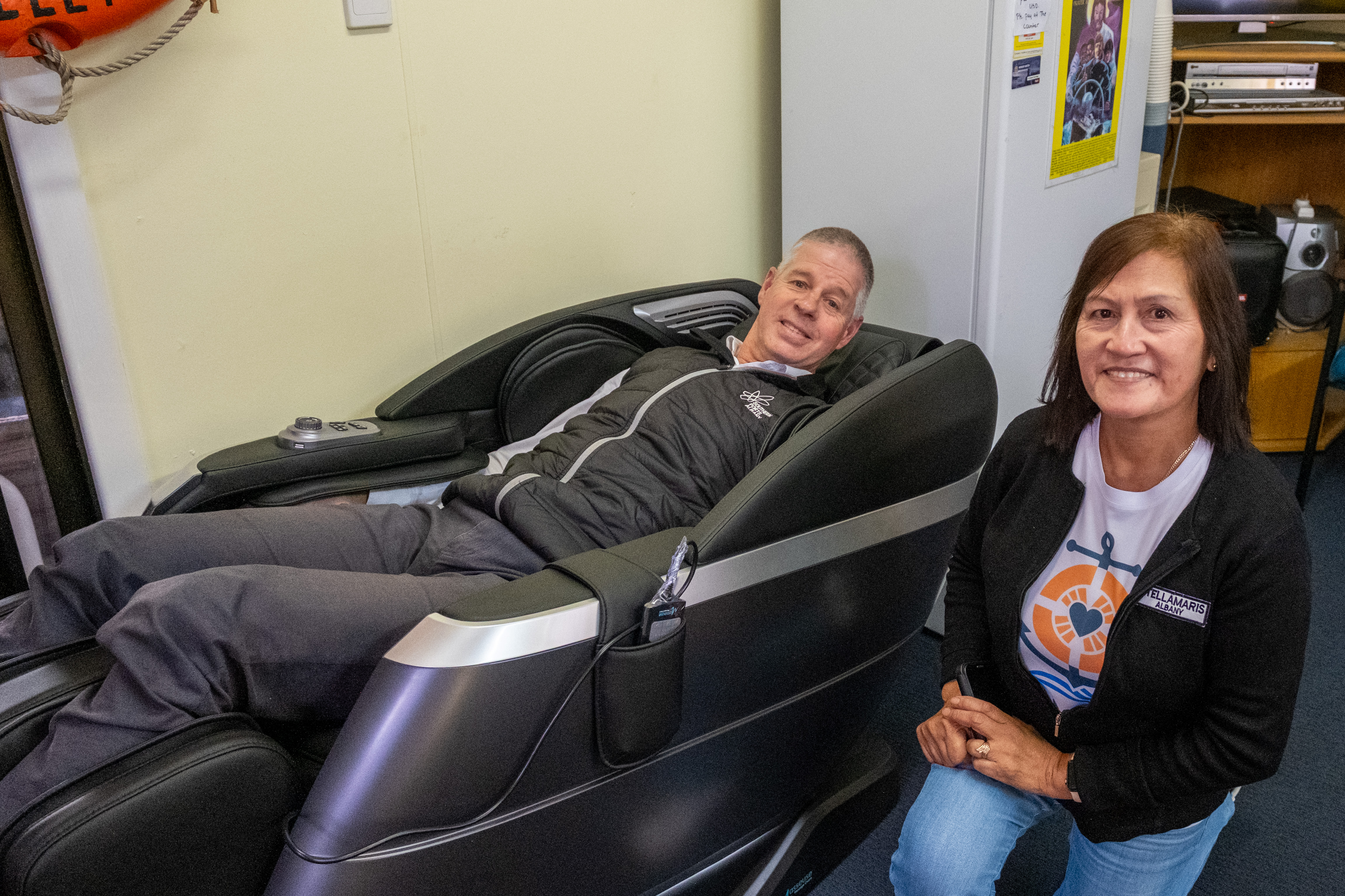 POA 2026 AUG Stella Maris Massage Chair 002 Southern Ports General Manager - Great Southern Paul McSweeney tries the massage chair donated to Stella Maris Albany as Centre Manager Marilou Lomas watches on.