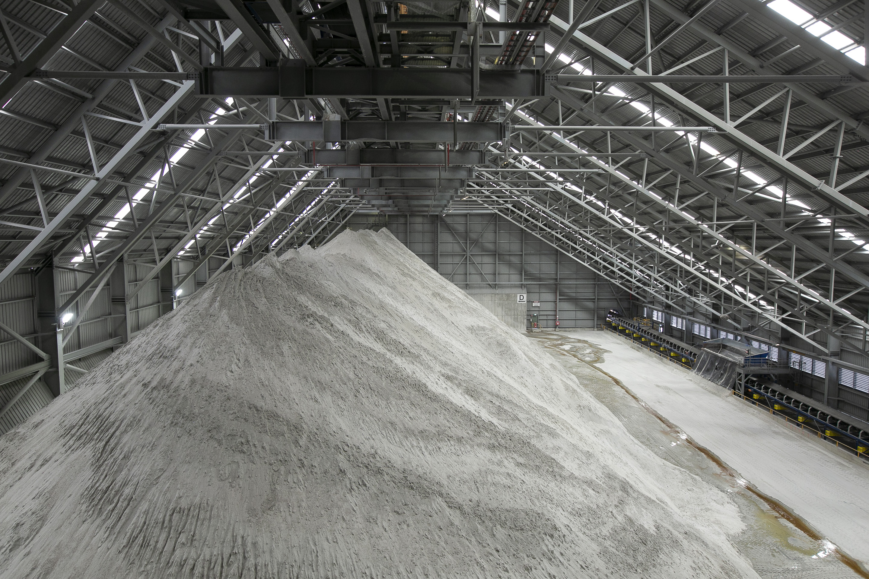 Spodumene stockpiles in a shed