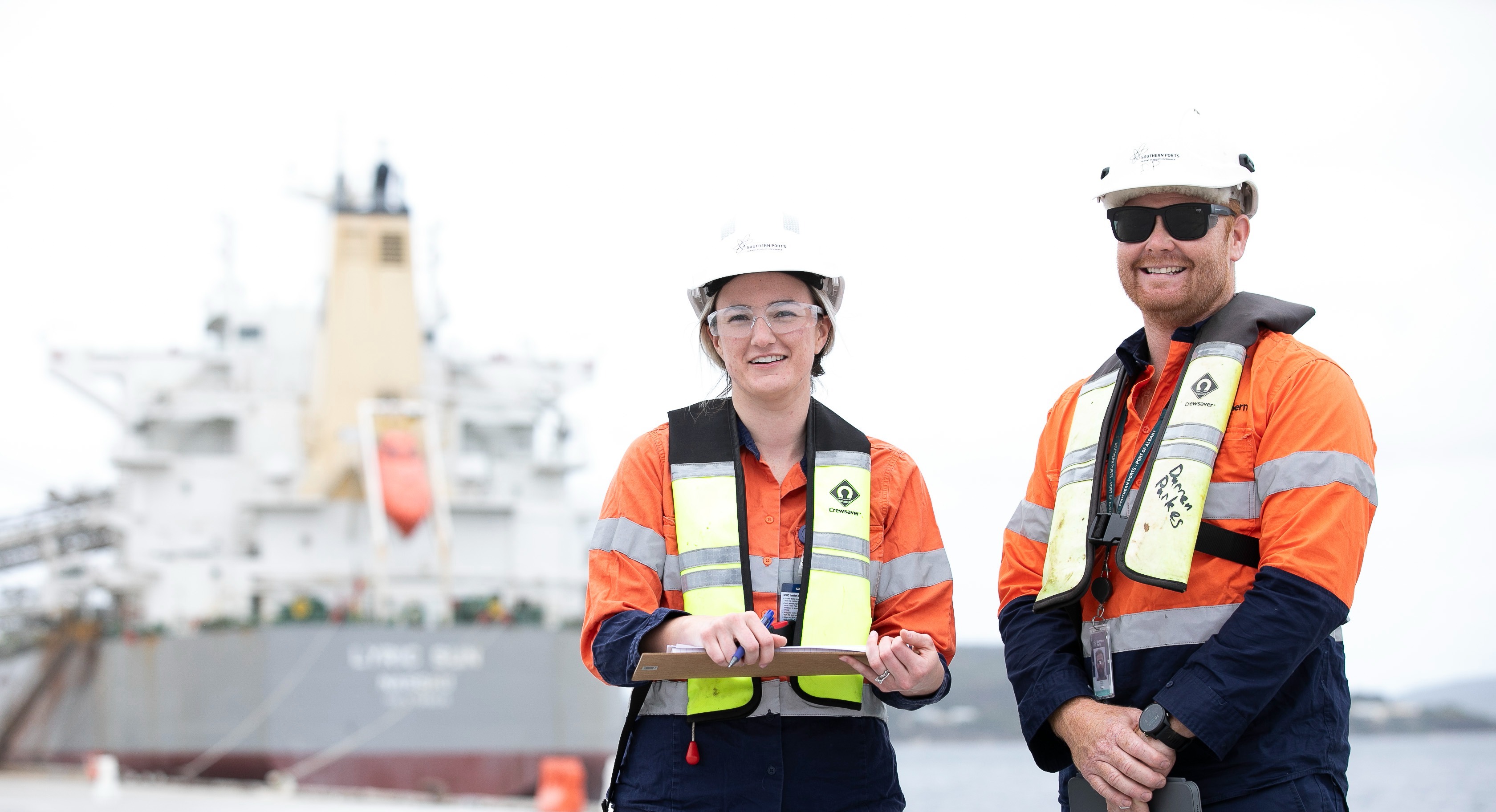 Two Southern Ports staff members infront of a vessel