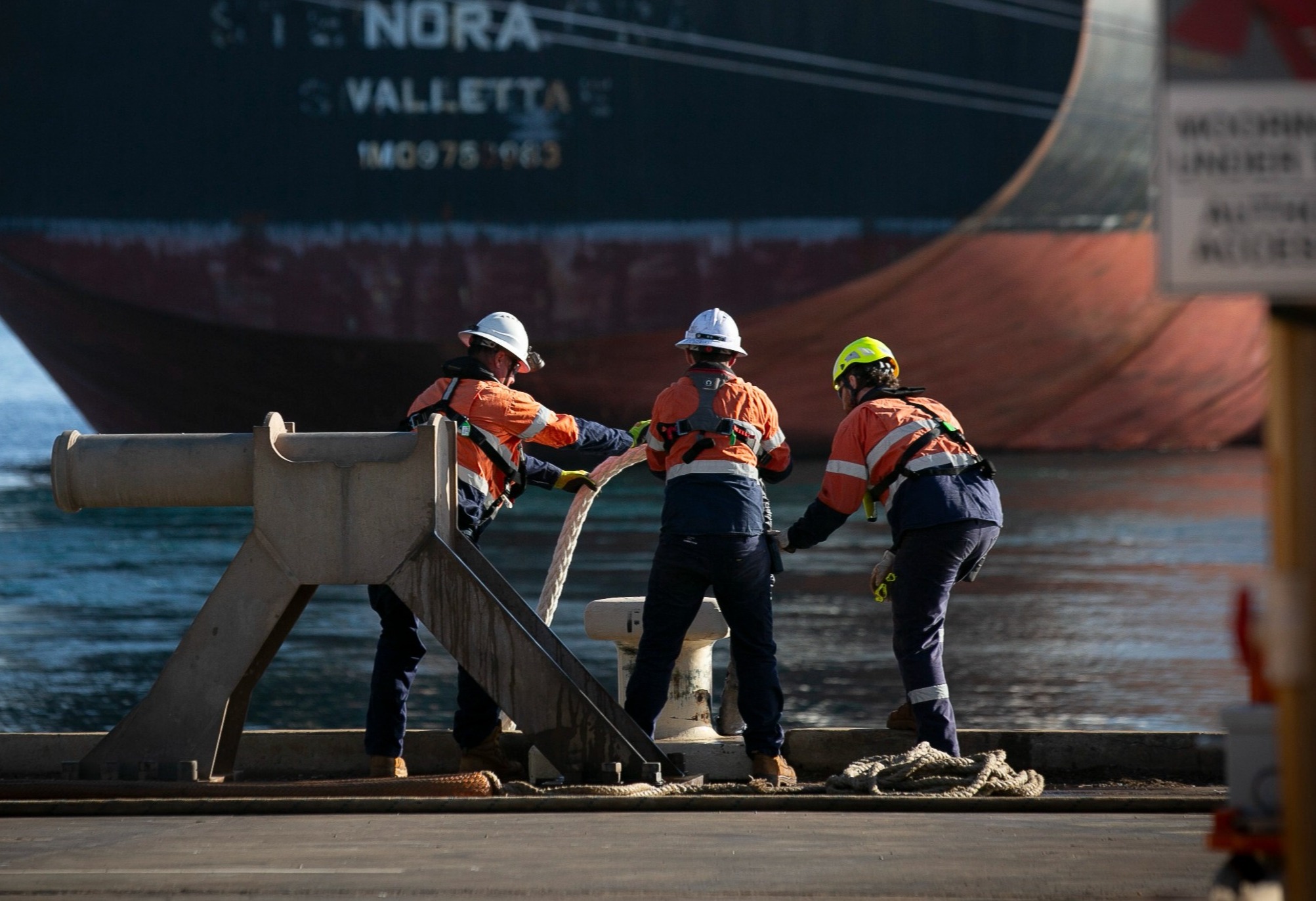 Three mooring crew tying up a vessel