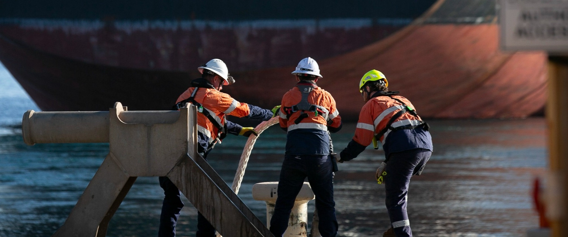 Three mooring crew tying up a vessel